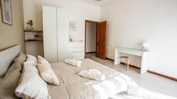 Een slaapkamer met een bed, bureau en kledingkast.