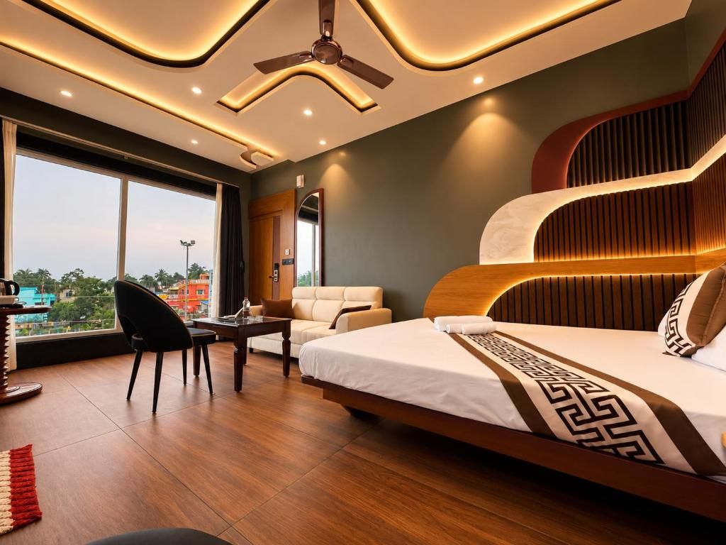 A modern hotel room with a large bed, a desk, a chair, and a view of the city.