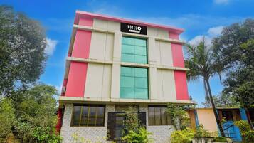 A multi-story hotel with a prominent sign indicating it is a company-serviced establishment.