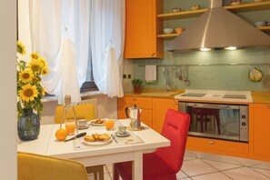 A kitchen with a dining table set for breakfast, a coffee maker, and a variety of kitchen utensils. - CasaNova • Jacuzzi • 9 guests • 4 bedrooms (Zona Industriale)