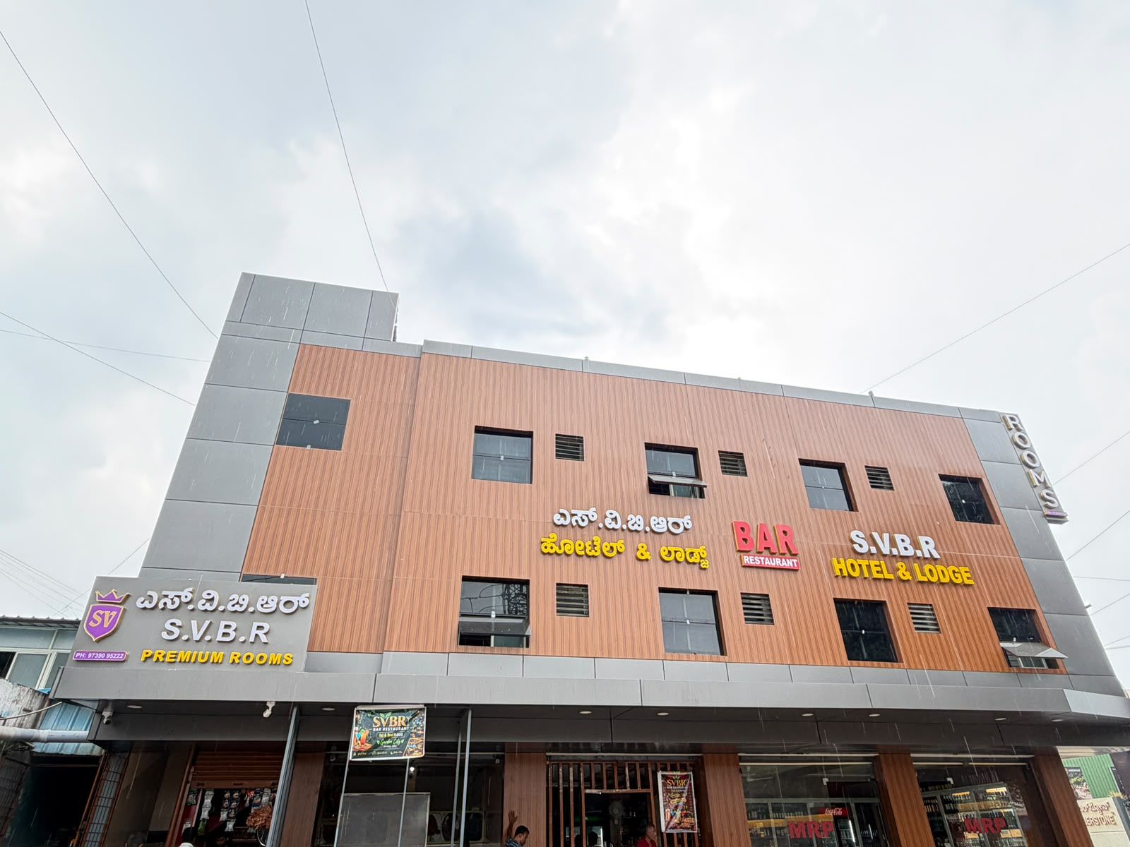 Un hotel con varios carteles que indican que ofrece habitaciones, un bar y un restaurante.