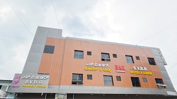 Un hotel con varios carteles que indican que ofrece habitaciones, un bar y un restaurante.