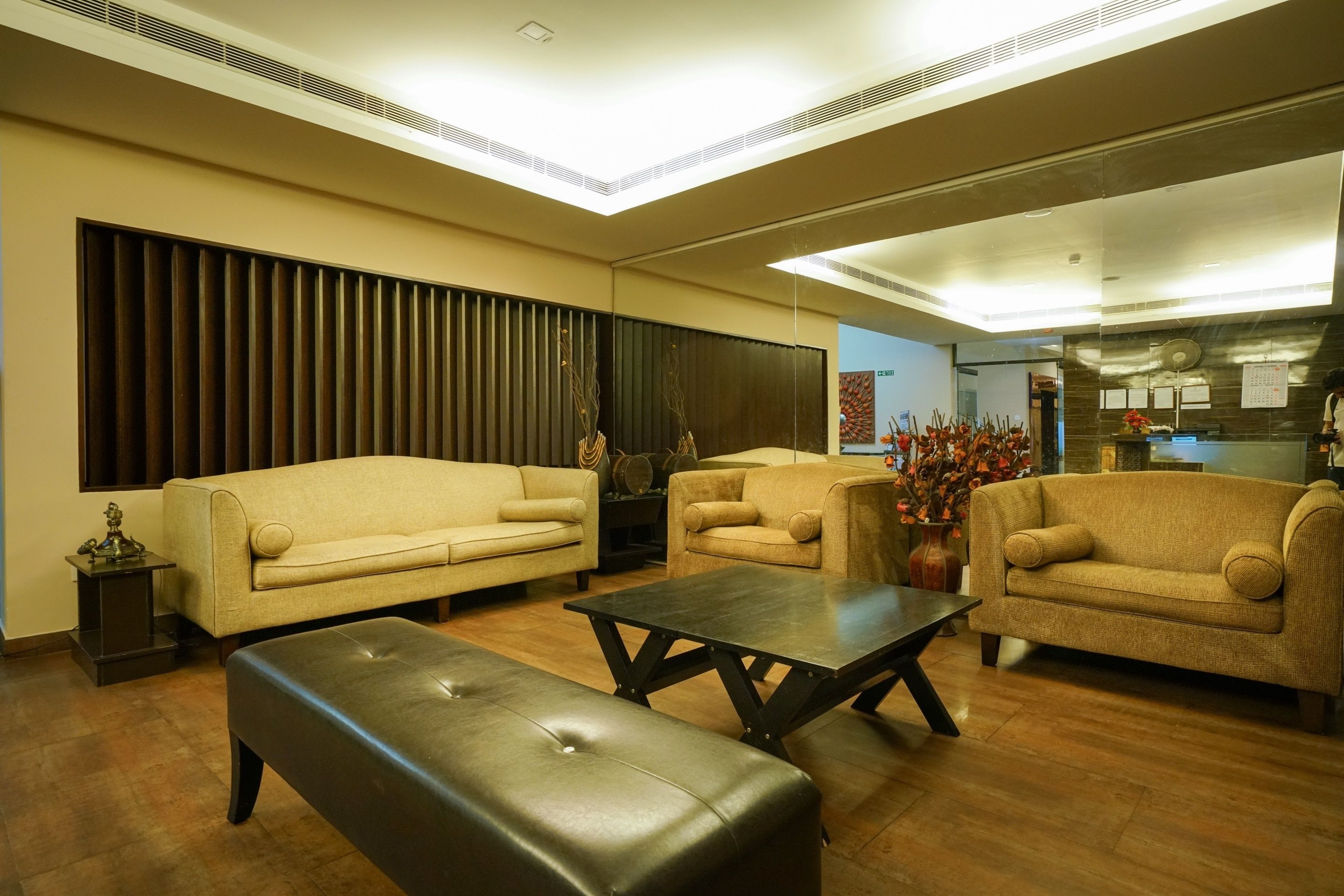 A modern living room with a sofa, armchairs, a coffee table, and a bench.
