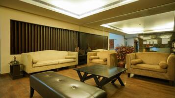 A modern living room with a sofa, armchairs, a coffee table, and a bench.
