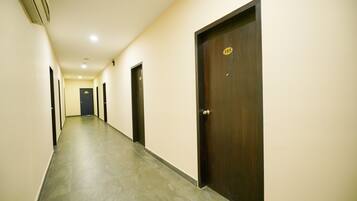 A long, narrow hallway with a tiled floor and doors on both sides.