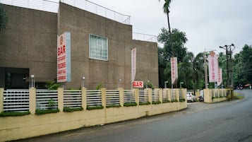 A building with multiple signs indicating the presence of a bar, banquet hall, car parking, and tourist home rooms.