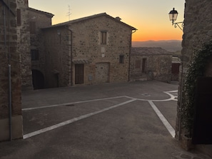 A narrow street with stone buildings, a clear sky, and a sunset. - Camigliano Wine State - Ghiandaie (Camigliano)