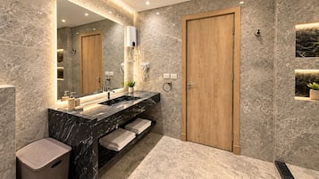 A modern bathroom with a marble sink, wooden doors, and a large mirror.
