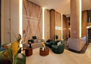 A modern lobby with a reception desk, seating area, and a marble wall. - Pool View Studio Tiba Golden Resort (Hurghada)