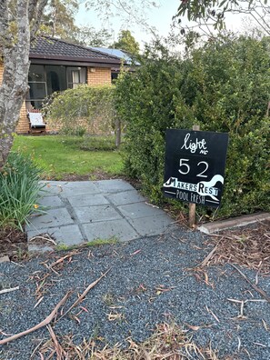Een bordje voor een restaurant genaamd 'Light 52' met de tekst 'MAKERS REST SCHOOL FRESH' in een woonwijk met een verharde oprit en groen.