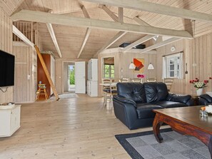 A spacious living area with a black leather sofa, a wooden coffee table, and a dining area with a table and chairs. - "Erikgine" - 900m from the sea by Interhome (Væggerløse)