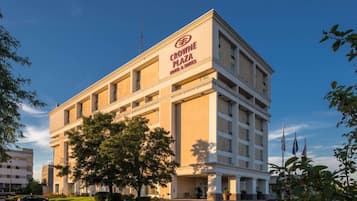 A multi-story hotel building with a prominent sign for Crowne Plaza Hotel & Suites.