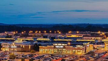 A large parking lot with multiple buildings, including a shopping center with a prominent sign.