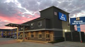 A Haven Inn & Suites building with a sign indicating it's now open. - Smoking 2 Queens Downtown + Free Breakfast (Houston)