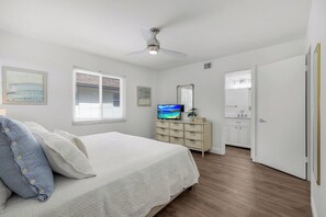 A bedroom with a bed, a dresser, a television, and a ceiling fan. - Harbour Lakes of Naples (Naples)