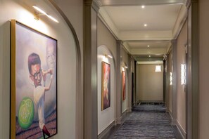 Hallway with framed art, arches, carpet runner, and soft lighting - Near James River + Rooftop Restaurant & Gym (Lynchburg)