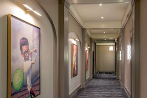 Hallway with framed art, arches, carpet runner, and soft lighting - 1BR King Steps to James River + Dining (Lynchburg)