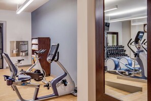 Exercise room with bikes, weights, mirror, and wood flooring - Stay Lynchburg Iconic Building + Rooftop Dining (Lynchburg)