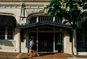 A building with a classical architectural style, featuring a grand entrance with a decorative archway and a large window. - Stay Lynchburg Iconic Building + Rooftop Dining (Lynchburg)