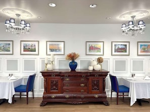 A dining room with a wooden buffet table, white walls, and framed artwork. - Near Gettysburg Battlefield + Restaurant & Pool (Gettysburg)