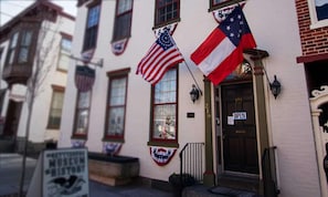 A building with a door marked 'OPEN' and American flags displayed. - Near Gettysburg Battlefield + Restaurant & Pool (Gettysburg)