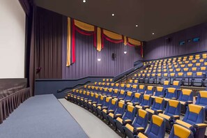 A theater with rows of blue and yellow seats, a stage, and a staircase leading to the upper seating. - Near Gettysburg National Military Park +Restaurant (Gettysburg)