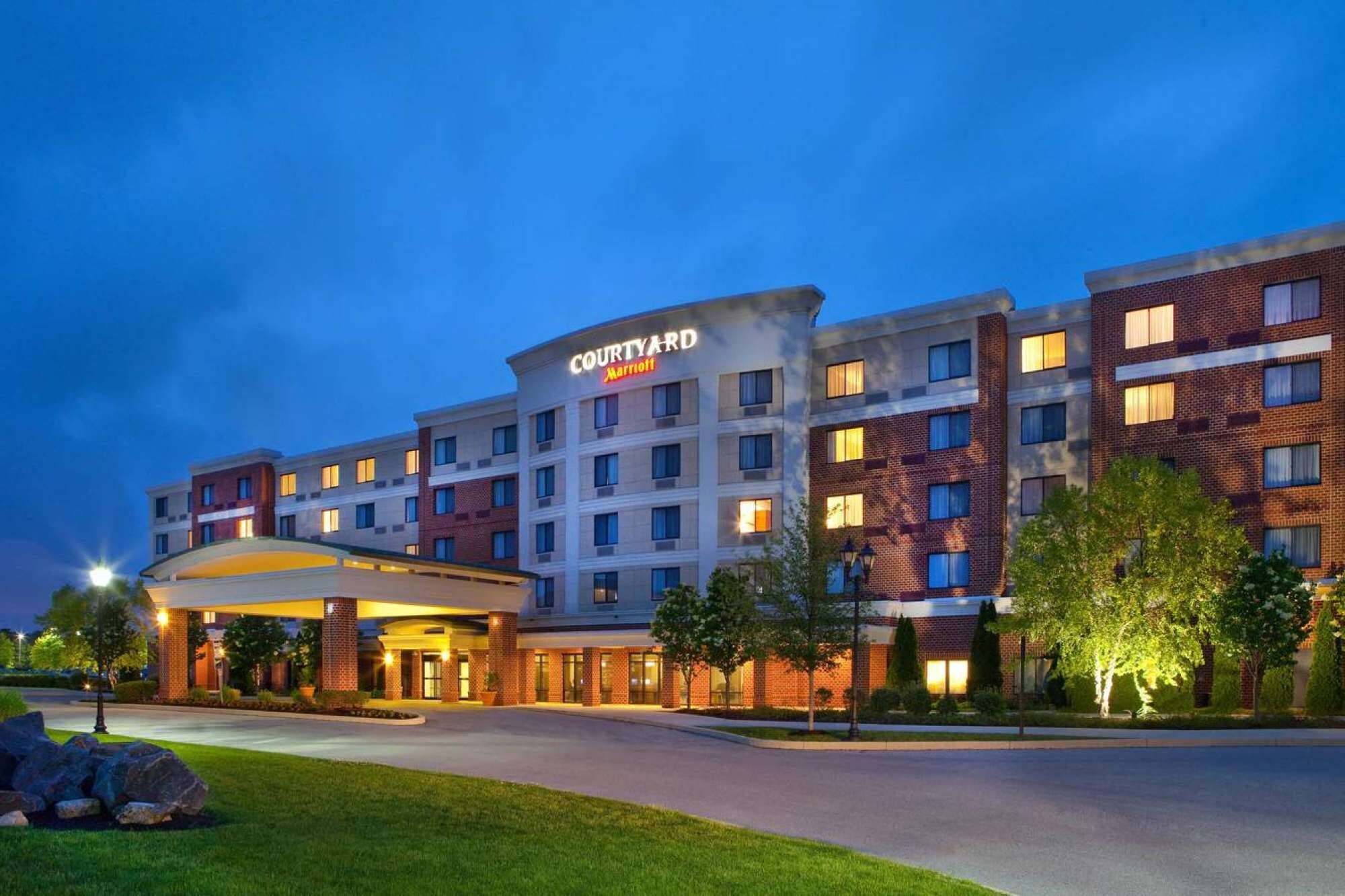 A Courtyard Marriott hotel with a modern design, featuring multiple floors and a well-lit entrance.