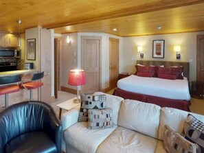 Una camera d'albergo con un letto, un divano, una scrivania e una sedia.