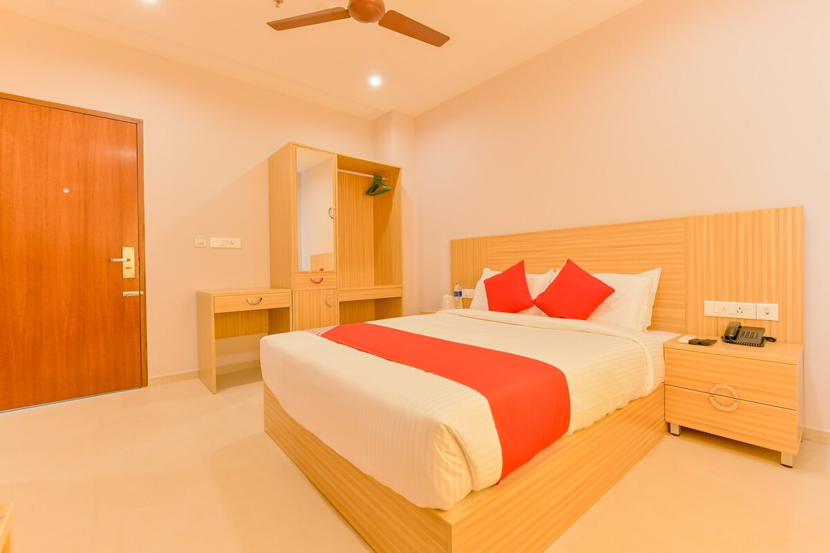 A hotel room with a bed, bedside table, nightstand, and a wardrobe.