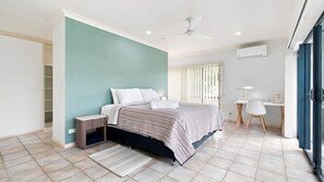 A bedroom with a bed, bedside table, and a desk with a chair. - Wongaling Whispers~ Escape to the gentle rhythm of Wongaling Beach (Wongaling Beach)