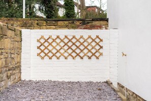 A white brick wall with a wooden lattice screen. - Peaceful Returns - 2 Bed House Near Roundhay Park (Leeds)