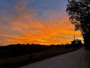 A rural road with a sunset sky. - Cozy 2-bedroom cabin style apartment in the peaceful Fayetteville area. (Elkins)
