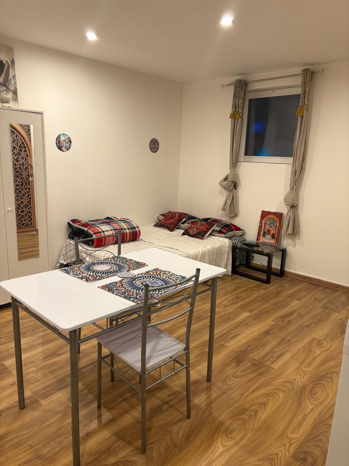 Een kamer met een bed, een tafel en een raam.