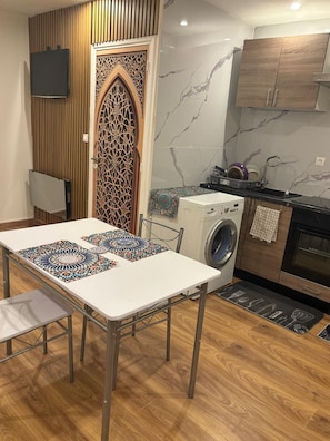 A compact kitchen with a washing machine, a microwave, and a sink. - Vrbo Property (Lille)