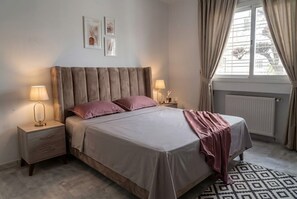 A bedroom with a bed, bedside tables, lamps, and a window with curtains. - sandra 27 (Tunis)