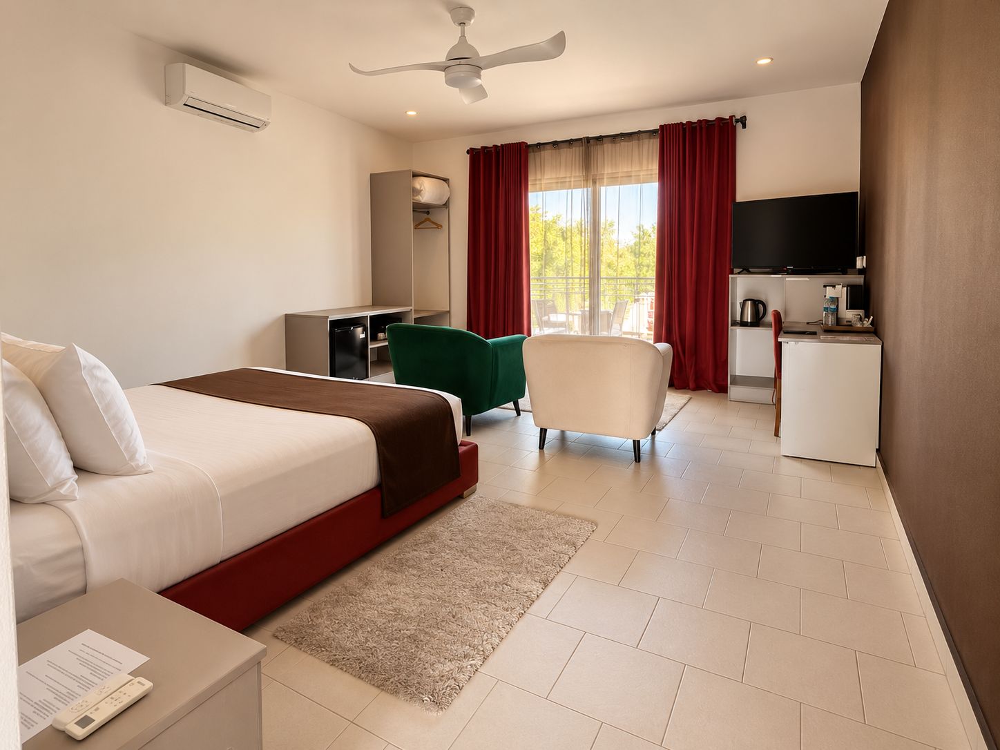 Habitación de hotel con cama, escritorio, silla, kitchenette y ventilador de techo.