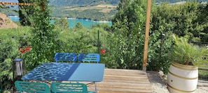 Un espace extérieur aménagé avec une table et des chaises, entouré de verdure et offrant une vue sur un paysage pittoresque.
