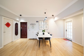 A dining area with a white table, black chairs, and a hanging light fixture. - Book&Bed-People's Square Jin'ou Wanguo (Huangpu District,)