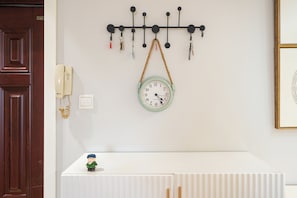 A wall-mounted key holder with keys and a clock below it. - Book&Bed-People's Square Jin'ou Wanguo (Shanghai)