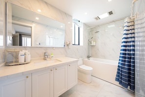 A modern bathroom with a marble countertop, a large mirror, a shower area, and a toilet. - Book&Bed-People's Square Jin'ou Wanguo (Huangpu District,)