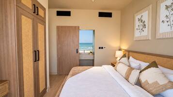 Une chambre d’hôtel avec un grand lit, une vue sur la plage et une armoire en bois.