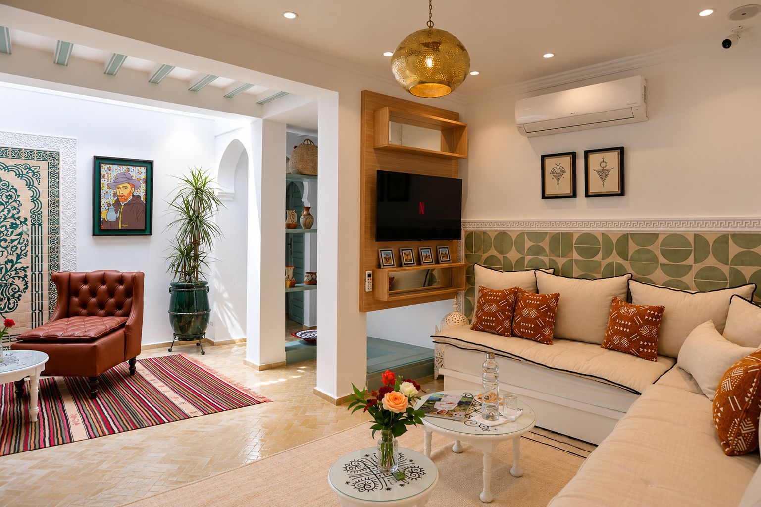 A living room with a sofa, armchair, and a coffee table with a vase of flowers.