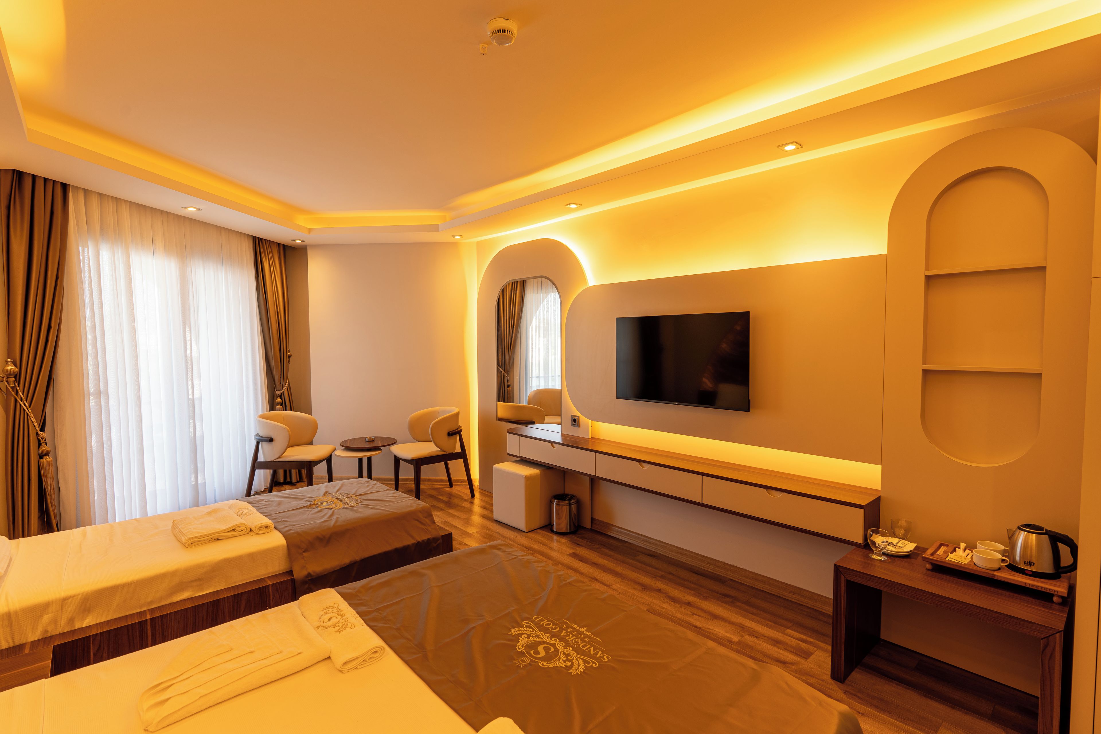 Une chambre d’hôtel moderne équipée d’un lit, d’un coin salon et d’une télévision.