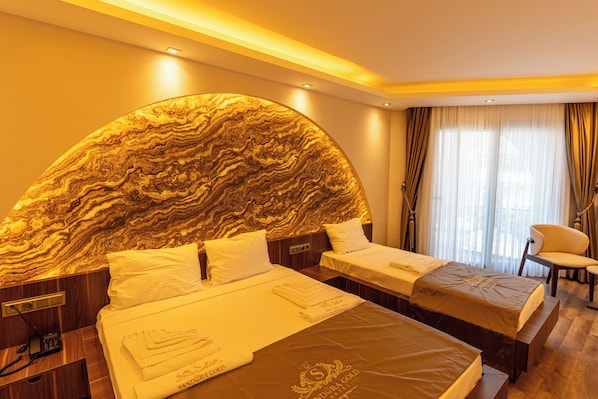 A hotel room with two beds, a marble headboard, a bedside phone, and a chair. - GOLD SANDORA HOTEL (ARSUZ)