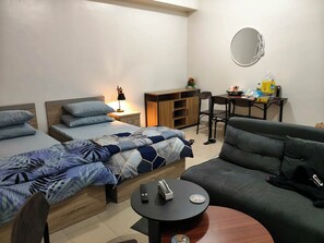 A modern bedroom with a double bed, a sofa, a small round table, and a desk with a chair. - Your Cozy Nest in Novaliches-SMDC Hills Residences Novaliches (Quezon City)