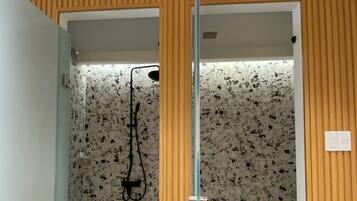 A bathroom with a shower, toilet, and a towel rack.