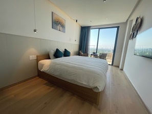 A modern bedroom with a large bed, a view of the outdoors, and a painting on the wall. - Song Thu Villa Hoi An (Hoi An)