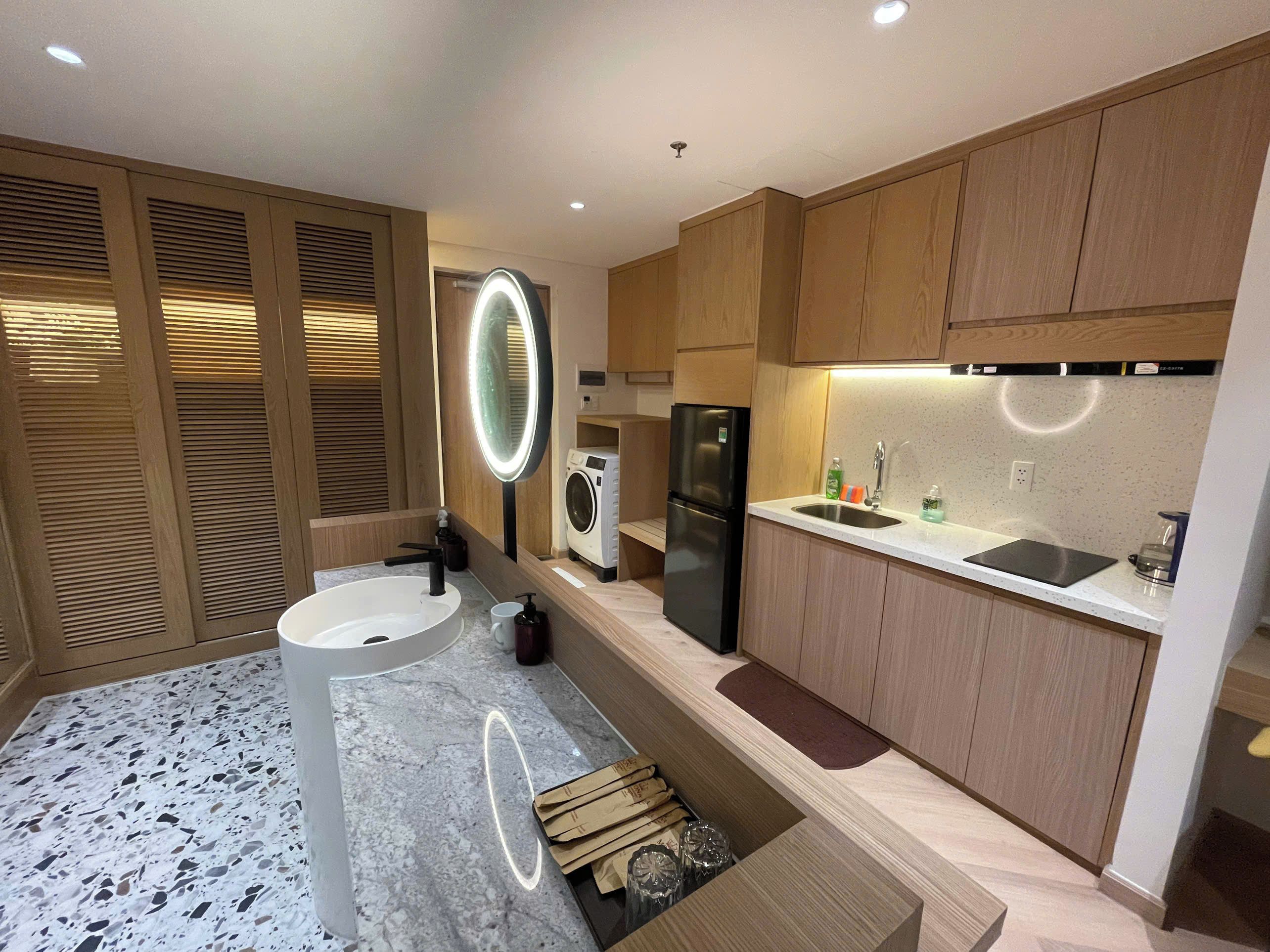 Una cocina moderna con lavadora integrada, refrigerador y pileta.