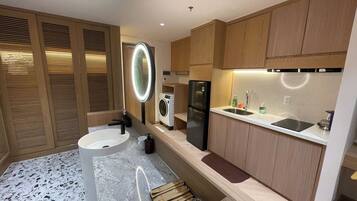 Una cocina moderna con lavadora integrada, refrigerador y pileta.