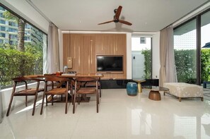 Una sala de estar moderna con comedor, televisor de pantalla plana y ventilador de techo.